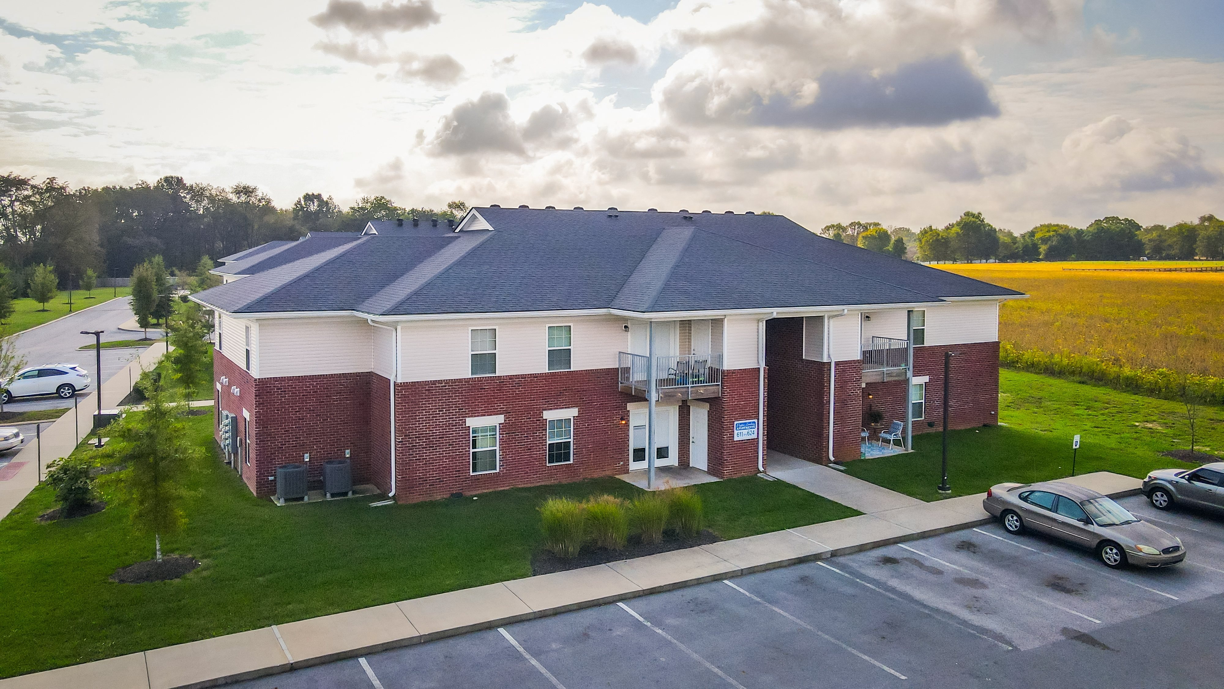 an aerial view of a brick building with cars parked in a parking lot